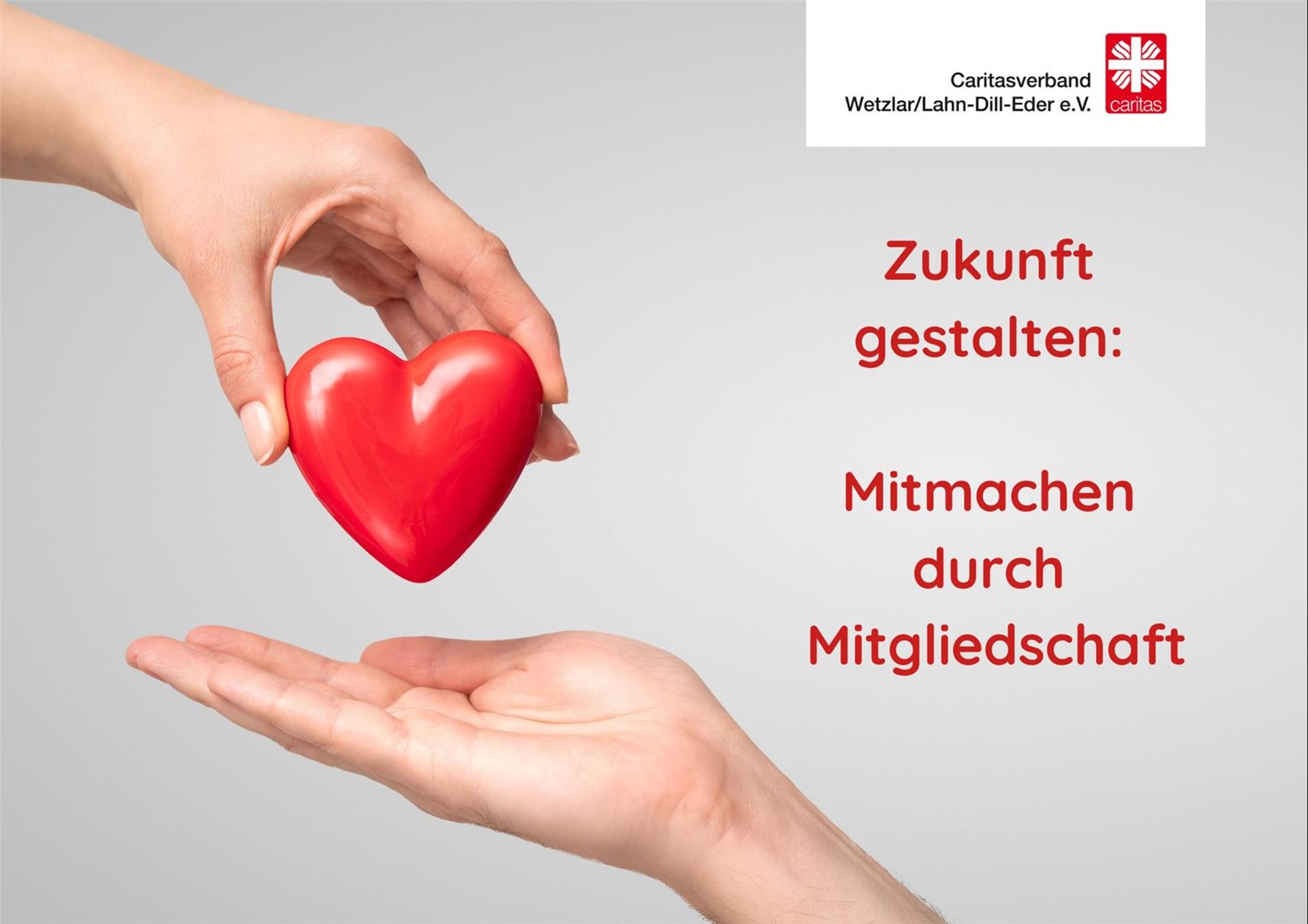 Eine Hand legt ein Herz als Symbol für Mitmenschlichkeit in eine geöffnete Hand.