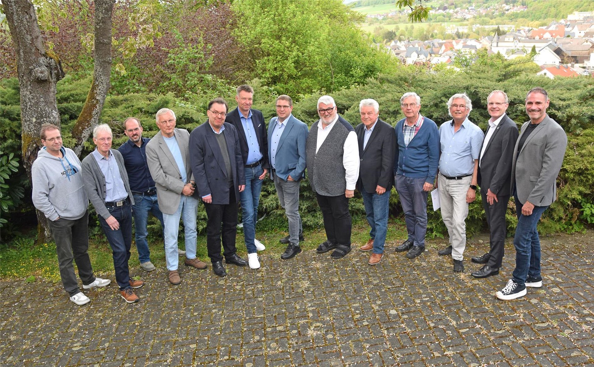 Mehrere Männer stehen für ein Gruppenbild zusammen und schauen in die Kamera.